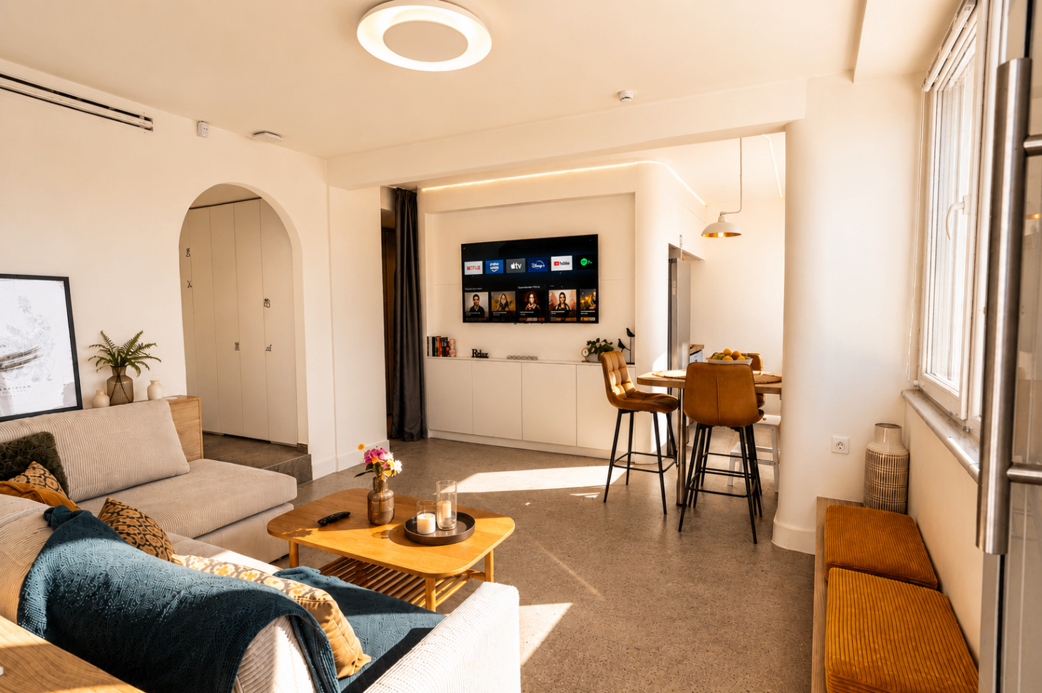 Niriis Suite 1 wide living area view with sofa, bench seating, and dining table