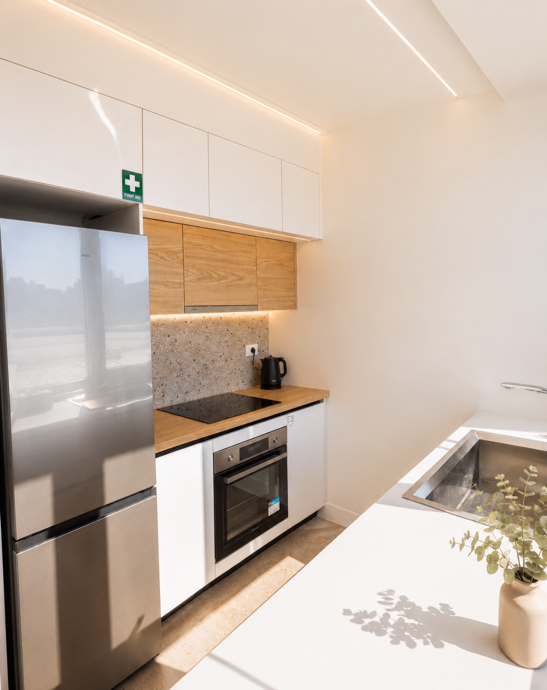 Niriis Suite 1 minimalist kitchen with wood cabinetry and terrazzo backsplash